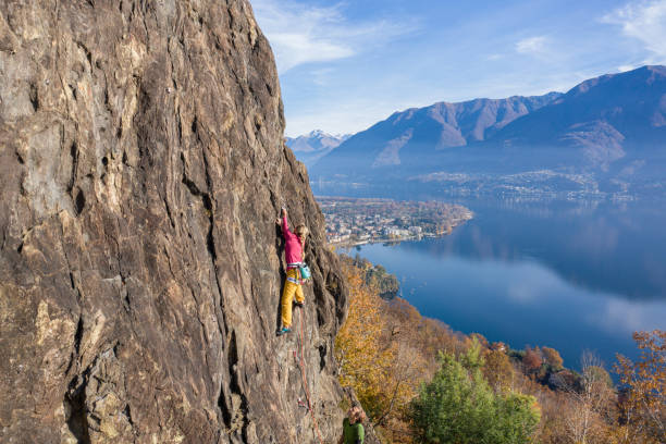 女性は自信を持って岩が山に登り、フィットネスライフスタイル - conquering adversity endurance adventure danger ストックフォトと画像