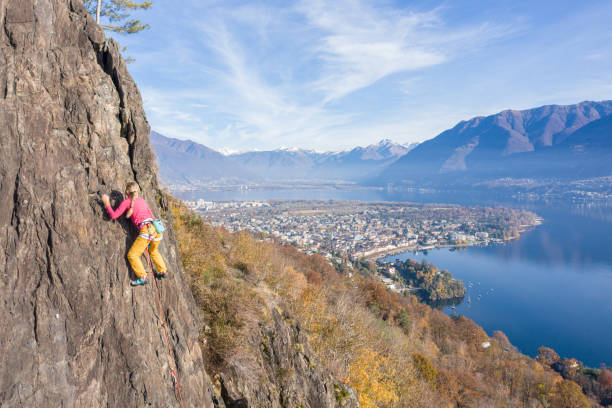 若いフィット女性は、スポーツルートでロッククライミングをリードし、屋外ロッククライミング - conquering adversity endurance adventure danger ストックフォトと画像