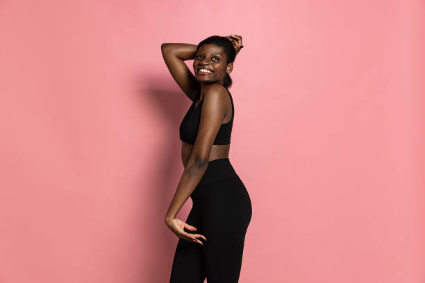 istock Young beautiful dark skinned woman smiling isolated on pink studio background with copy space for ad. 1361905647