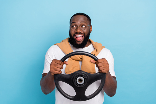 Photo of funny driver hold steering wheel look empty space wear white t-shirt jumper front-tie isolated blue color background