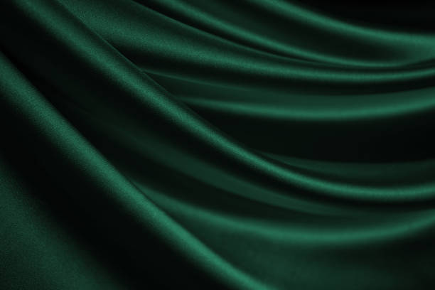 Dark green silk satin velvet. Nice soft folds. Shiny fabric. Dark green silk satin velvet. Nice soft folds. Shiny fabric. Wavy lines. Elegant background for design. emerald stock pictures, royalty-free photos & images