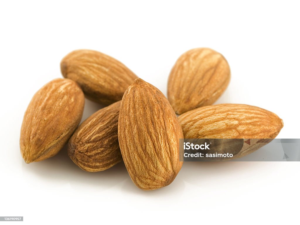 A pile of 6 raw almonds on a white background Raw Almonds.. Almond Stock Photo