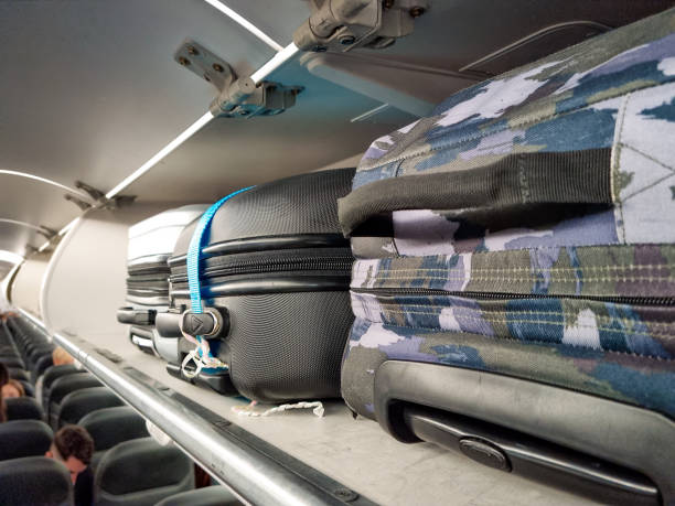 istock Carry on luggage in airplane storage 1361912857