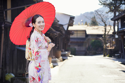 Asian woman tourists. Beautiful girl wearing traditional japanese kimono in popular in Old village at Nagano Prefecture, Japan.
