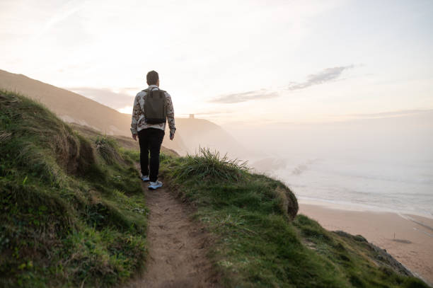 istock Rear view of a man hiking at sunset 1361914984
