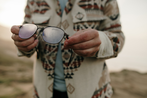 A person holding foggy glasses