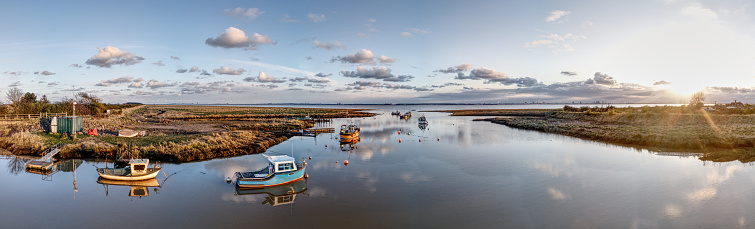 Boats moored beneath a sunny spring sunset at small harbour Stone Creek.