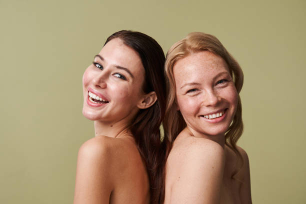 istock Vivacious girls laughing out loud while posing back to back to each other 1361916060