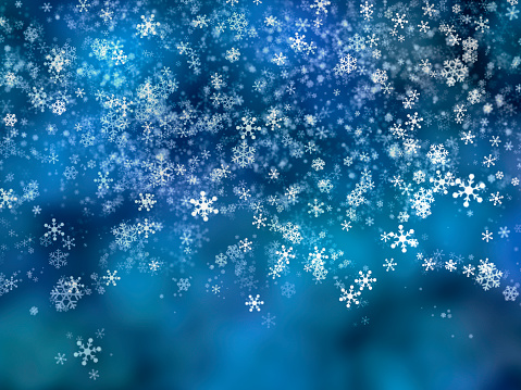 Christmas background. Snowflakes falling against a blue glowing background.