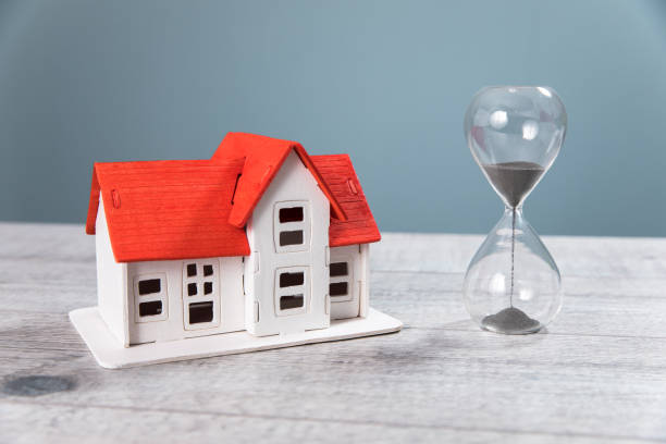 istock house model and hourglass on table 1361920580