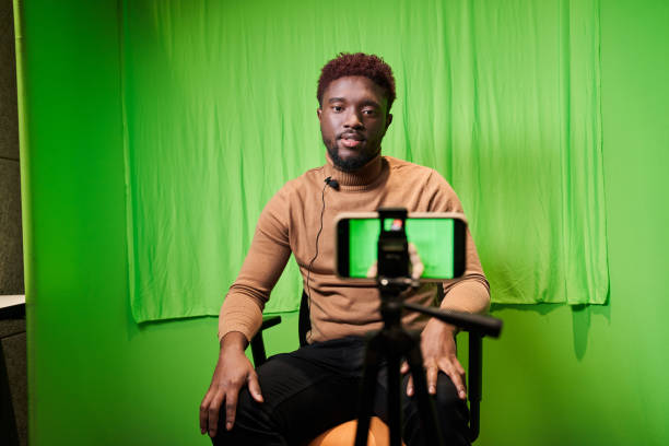 Television presenter in TV camera in studio over the green stock photo
