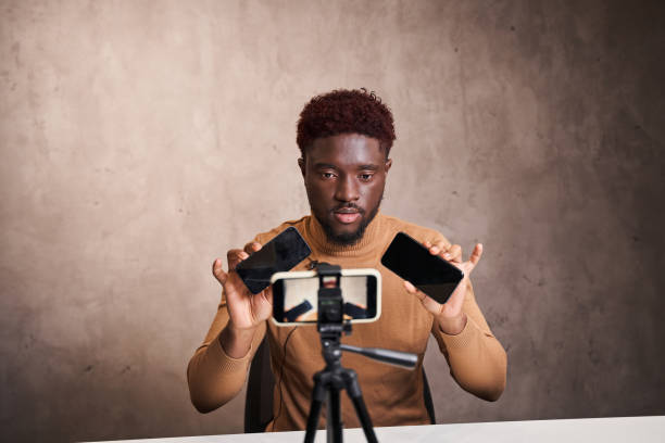 istock Multiracial guy speaking in front of smartphone camera for his blog channel 1361925235