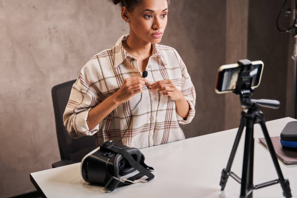istock Woman vlogger keeping microphone at clothes while preparing to recording her video blog 1361925285