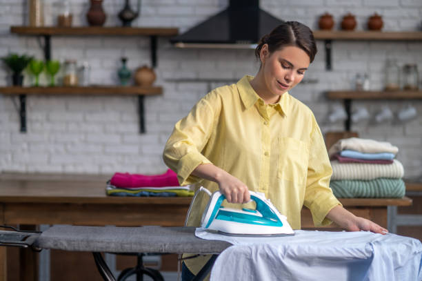 다림질 보드에 주름진 옷을 다림질 하는 농축 주부 - iron women ironing board stereotypical housewife 뉴스 사진 이미지