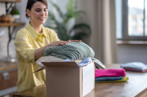 istock Happy lady placing sweaters in the carton 1361926102