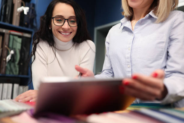 istock Two women looking into digital tablet and smiling in workshop 1361928463