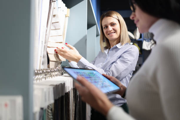 istock Woman with digital tablet selecting fabric in workshop with consultant 1361928465