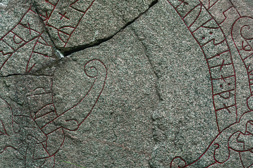 Close up of a cracked rune stone with red runes