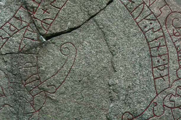 Background texture from a detailed close up of an old cracked rune stone with red runes