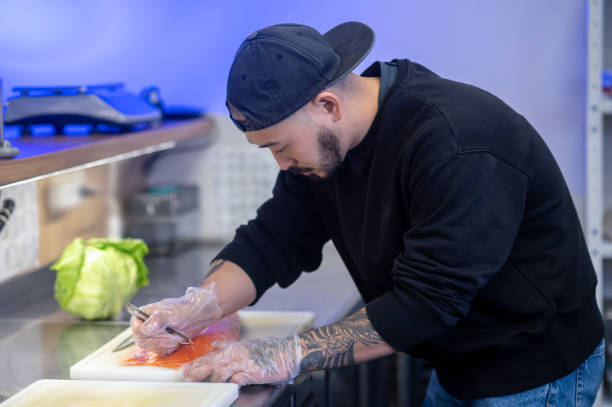 istock Sushi chef cutting fish and making sushi 1361934193