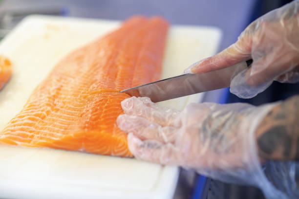 istock Close of mans hands cutting fish on a cutting board 1361934200