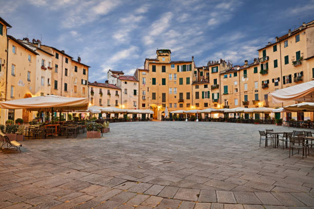 Lucca, Tuscany, Italy: the ancient elliptical Amphitheater square with outdoor bars and restaurants in the old town of the medieval city Lucca, Tuscany, Italy: the ancient elliptical Amphitheater square (Piazza dell'anfiteatro) with outdoor bars and restaurants in the old town of the medieval city lucca stock pictures, royalty-free photos & images