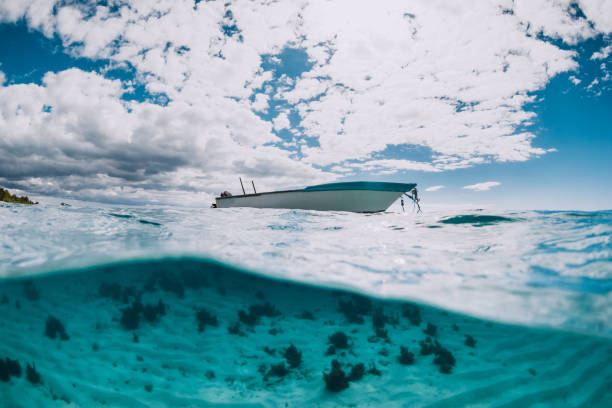 istock Tropical transparent ocean with white boat in Mauritius. Split view in water. 1361939220