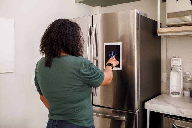 istock Young woman checking information from smart fridge 1361939984