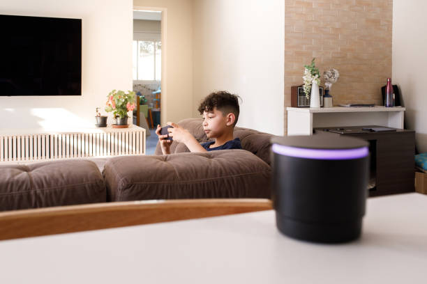 istock Boy playing with smartphone and interacting with smart speaker 1361940005