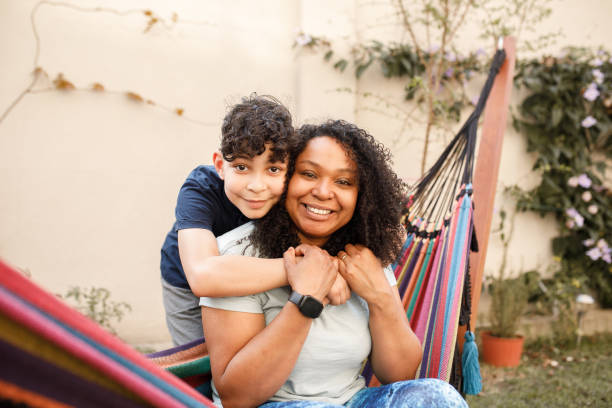 istock Mother and son hugging, looking at the camera and smiling 1361940019