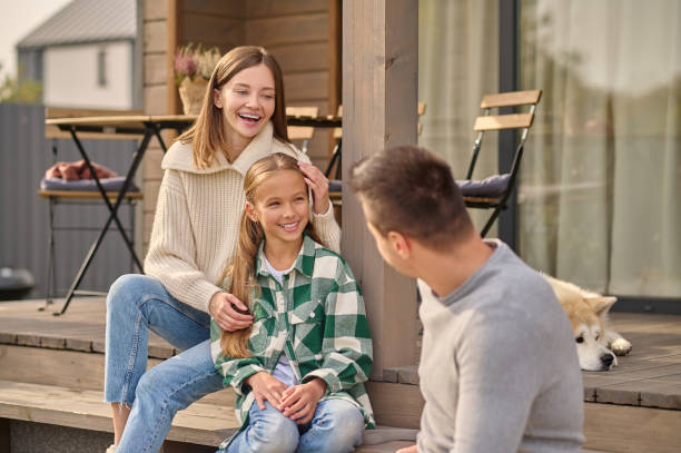 istock Woman touching daughter looking at man sitting on steps 1361941082