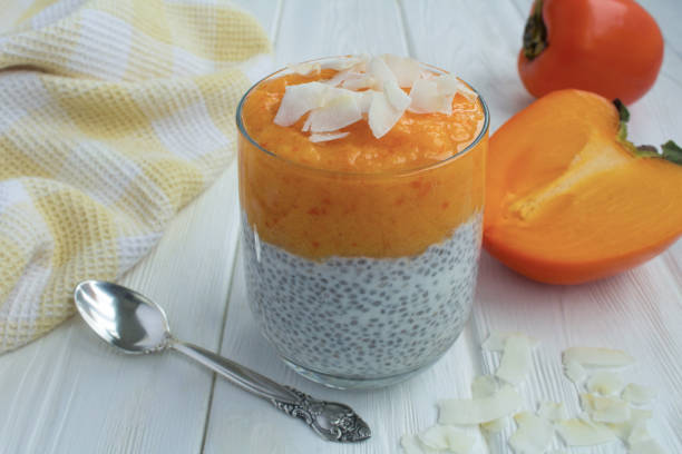istock Pudding with chia seed, persimmon and coconut chips on the white  wooden background. Close-up. 1361947560