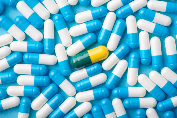 istock Many blue and white pills with one different in the middle 1361951456