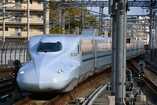 31st March 2012 - Tokyo, Japan.\nShinkansen N700 bullet train at a Tokyo train station with people on the platform.