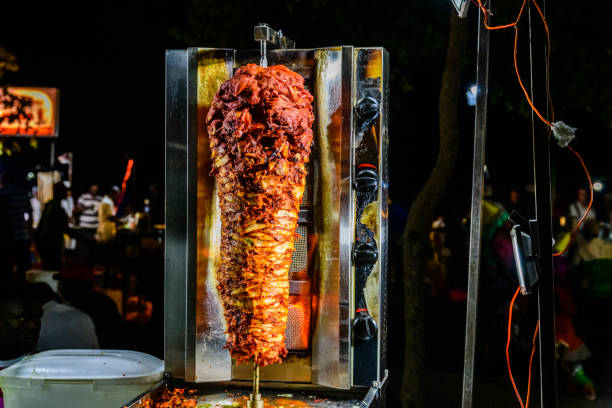 carne de shawarma árabe se preparando em espeto no restaurante de comida de rua nos jardins de forodhani. zanzibar - restaurant chicken roasted spit roasted - fotografias e filmes do acervo