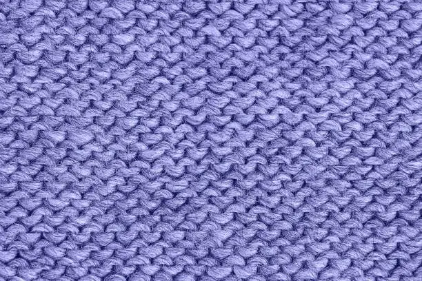 Lilac very peri knitted texture, handmade knitwear, reverse stitch. Color of the year 2022 very peri toned. Abstract background, copy space.