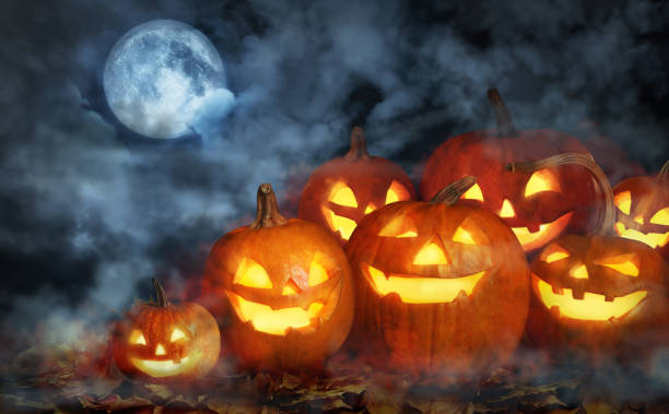 istock Scary Jack O Lantern pumpkins surrounded by mystical mist under full moon on Halloween 1361965658
