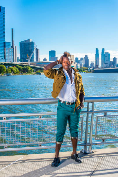 istock a young black guy with mohawk hair is standing by a river, confidently looking forward. 