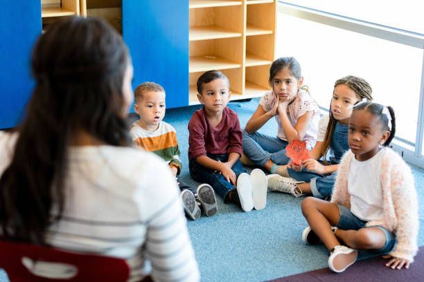istock Children sit in circle on floor for story time 1361969333