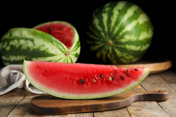 istock Board with yummy watermelon slice on wooden table 1361971820