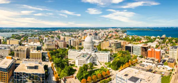 Wisconsin State Capitol and Madison skyline panorama. The Wisconsin State Capitol, houses both chambers of the Wisconsin legislature, Supreme Court and the Office of the Governor.