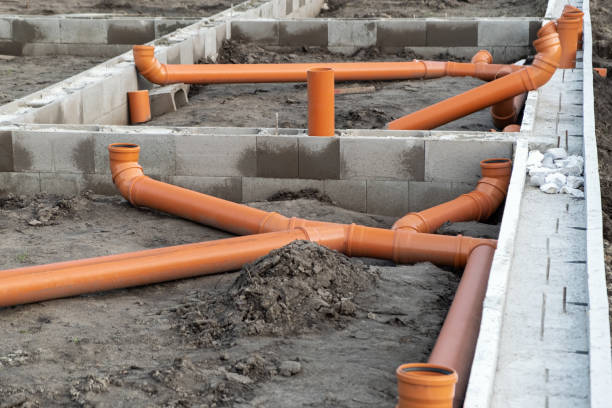 New Installed pipework system. Sewer Line developed and mounted on the construction site. New Installed pipework system. Sewer Line developed and mounted on the construction site. New Orange PVC plastic Drainage pipe Tube laying underground pipes stock pictures, royalty-free photos & images