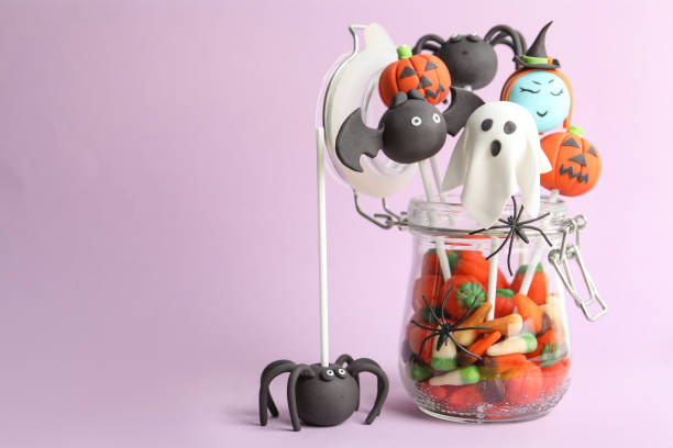 istock Delicious Halloween themed cake pops on pink background, space for text 1361977227
