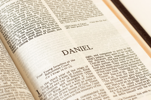 Daniel Holy Bible Old Testament prophet. Open Scripture Book inspired by God Jesus Christ. Reading and studying prophesy. A Christian biblical concept. A close-up.