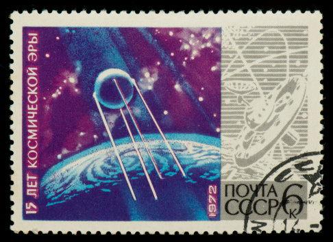 soviet postage stamp from 1972 with a drawing of planets and space. This stamp was released for the 15th anniversary of the space age