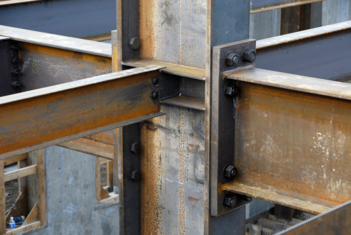 Steel I beams joined by welding and bolts at joint.