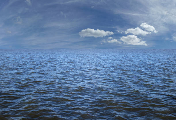 istock Blue sky and clouds over dark moody ocean nautical background 1361992845