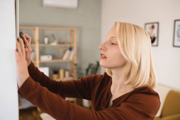 istock Young woman adjusting a smart house system 1361996988