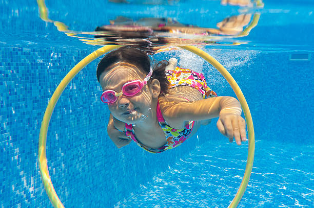 istock Happy kids swims underwater in pool 136200314