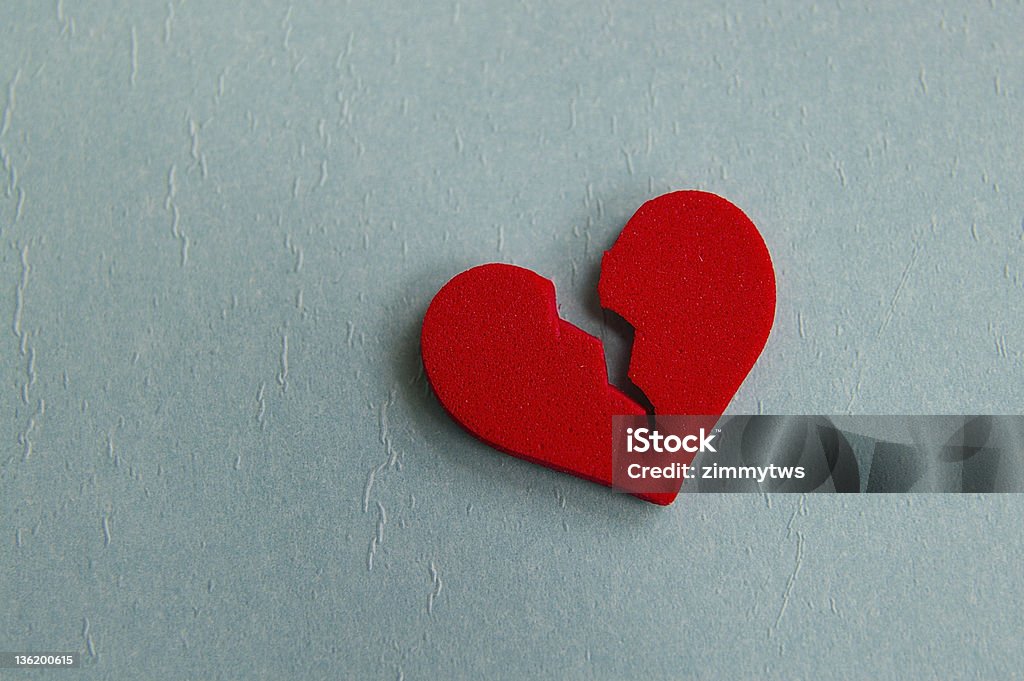 A red broken heart made out of foam red broken heart, closeup on blue Broken Stock Photo